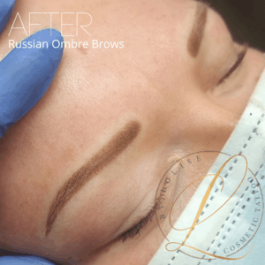 Close-up of a person's eye after Russian Ombre Brows cosmetic tattoo. A gloved hand holds skin, a mask is visible.