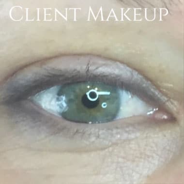 Close-up of a human eye with green irises and subtle makeup, with 'CLIENT MAKEUP' text visible at the top.