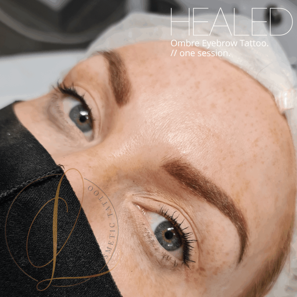 Close-up of a person with blue eyes and beautifully shaped, healed ombre eyebrow tattoos after one session.